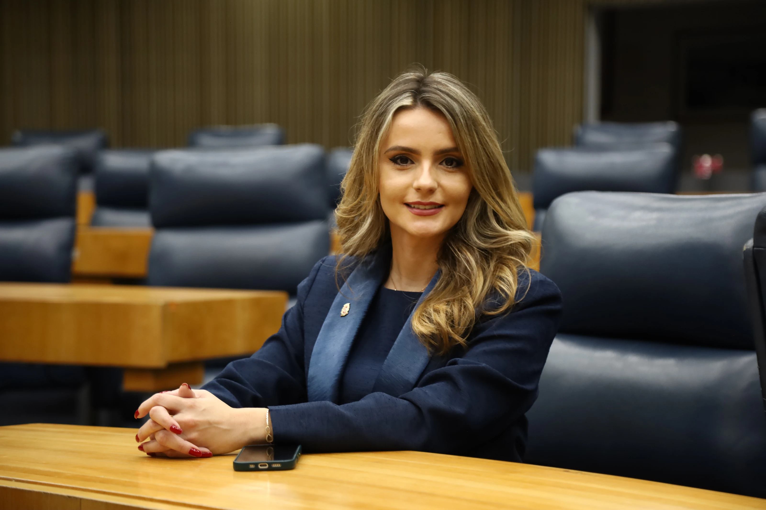 Amanda Vettorazzo sentada numa bancada do plenário da Câmara Municipal de São Paulo